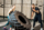 Athletic woman pushing a big tire training with a handsome trainer in the gym